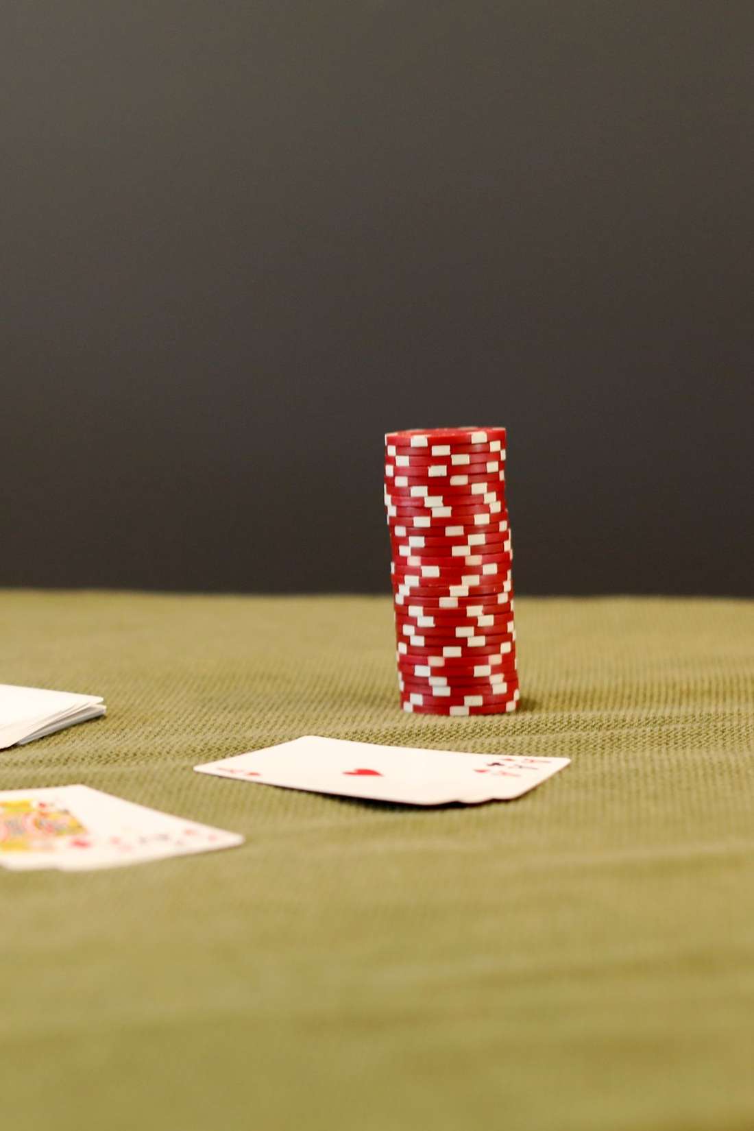 Kartu remi dan chip poker di atas meja hijau
